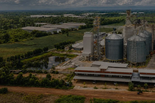 Large livestock feed pellet production line plant aerial view with silos and factory buildings