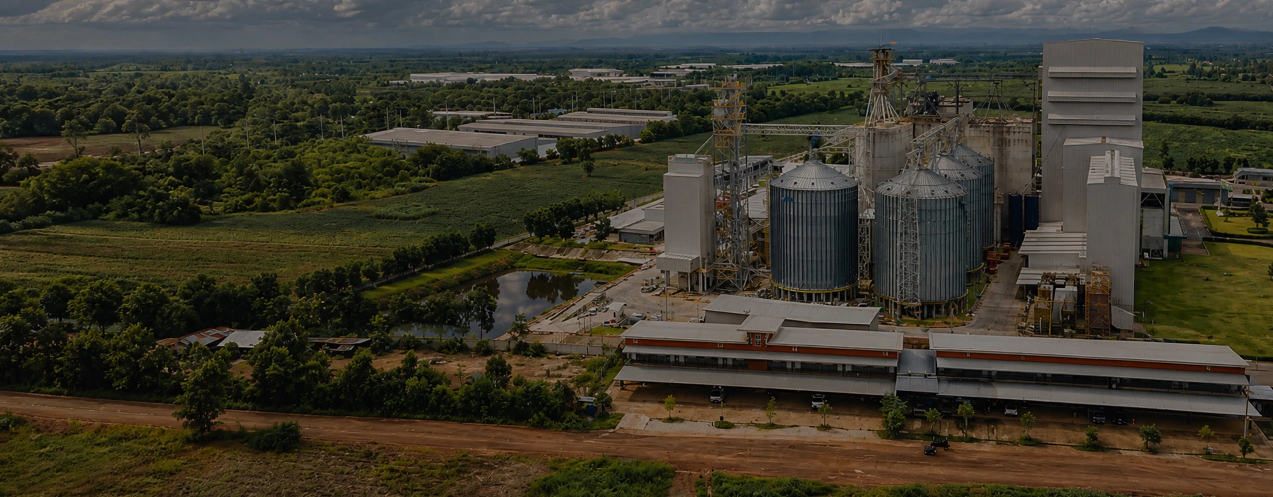 Large livestock feed pellet production line plant aerial view with silos and factory buildings